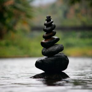 Balanced stones in a serene river evoke a sense of peace and tranquility.